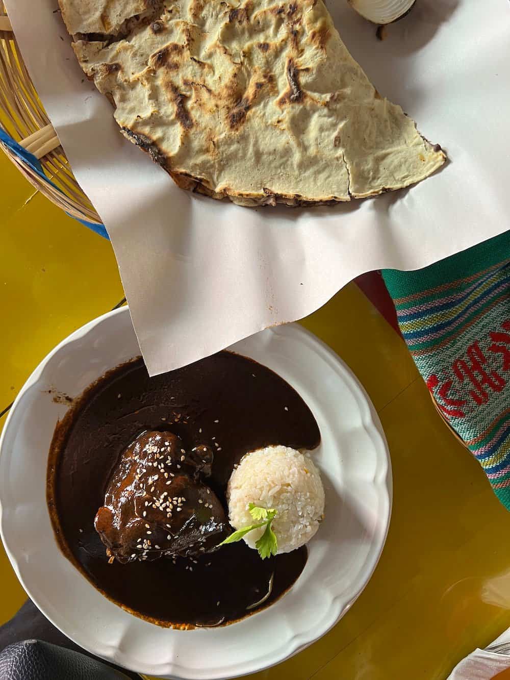 Mole and tlayuda served in a white bowl in Puerto Escondido. 