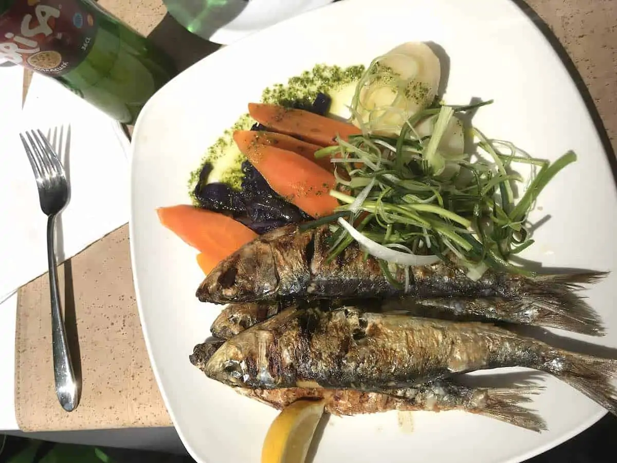 Grilled sardines on a white plate in Lisbon.