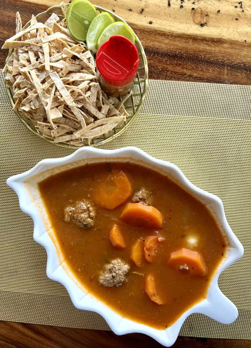 A bowl of sopa de albondigas in a white bowl. 