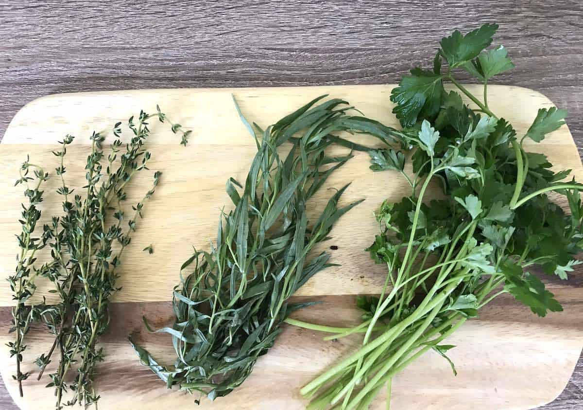 Thyme, tarragon and parsley on a wooden board. agon,