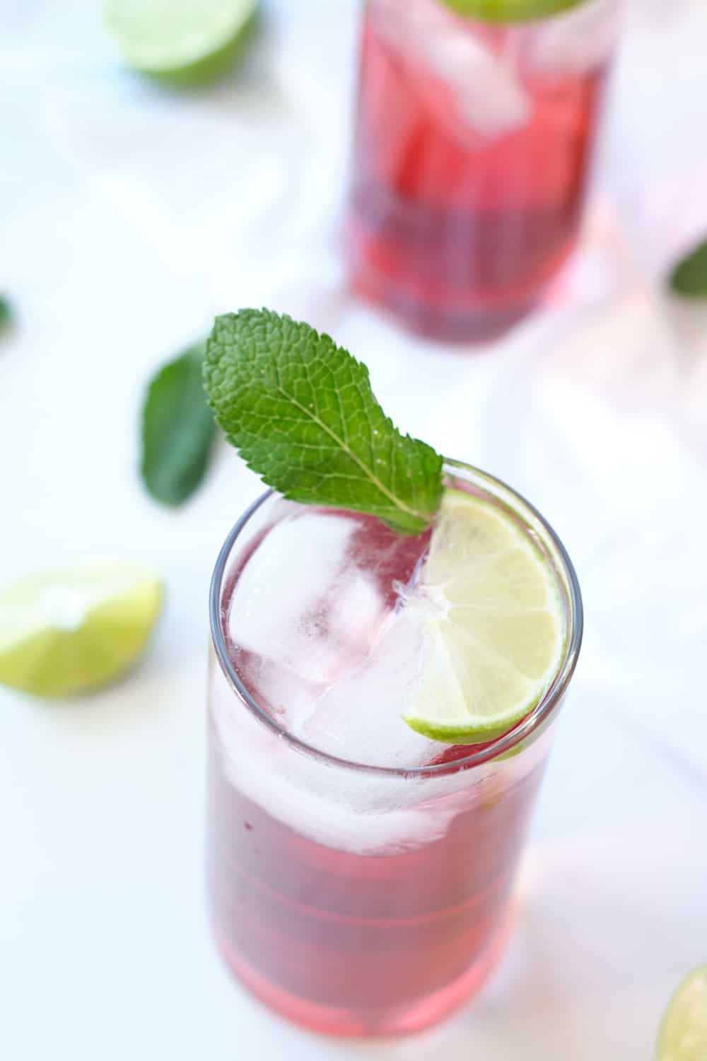 Two glasses of fresco de flor de jamaica with ice.