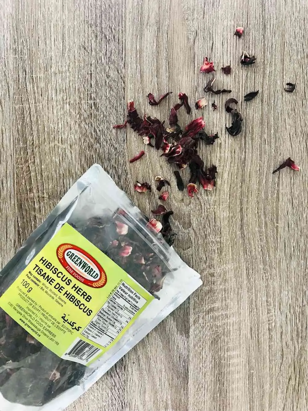 Package of hibiscus flowers in a bag on a brown table.