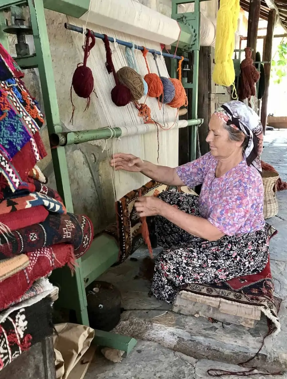 Woman demonstrating weaving at Etrim Hali Carpet Cooperative.