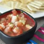 A bowl of shrimp ceviche Guatemalteco with a woven napkin.