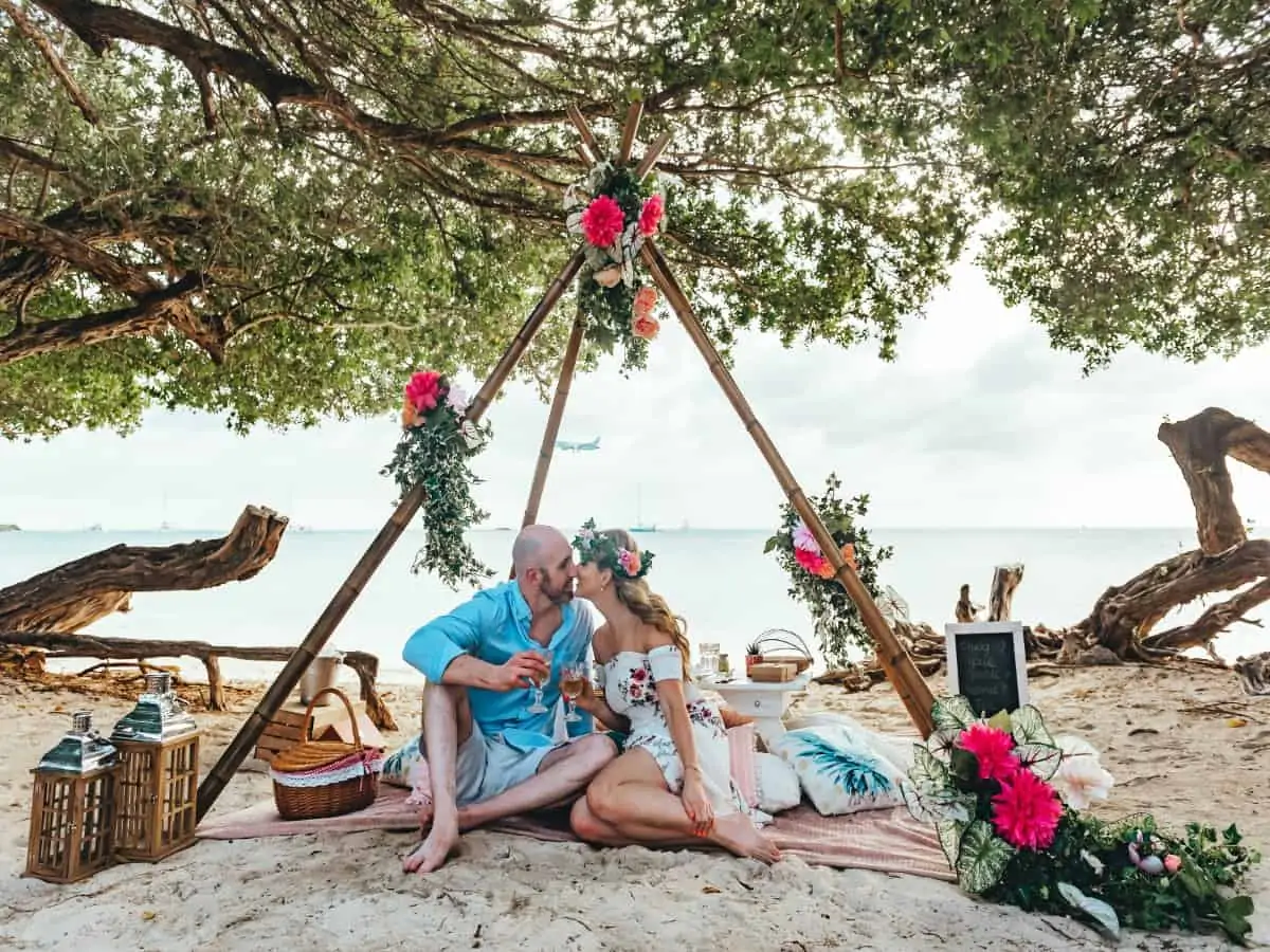 A man and a woman on a beach having a romantic picnic