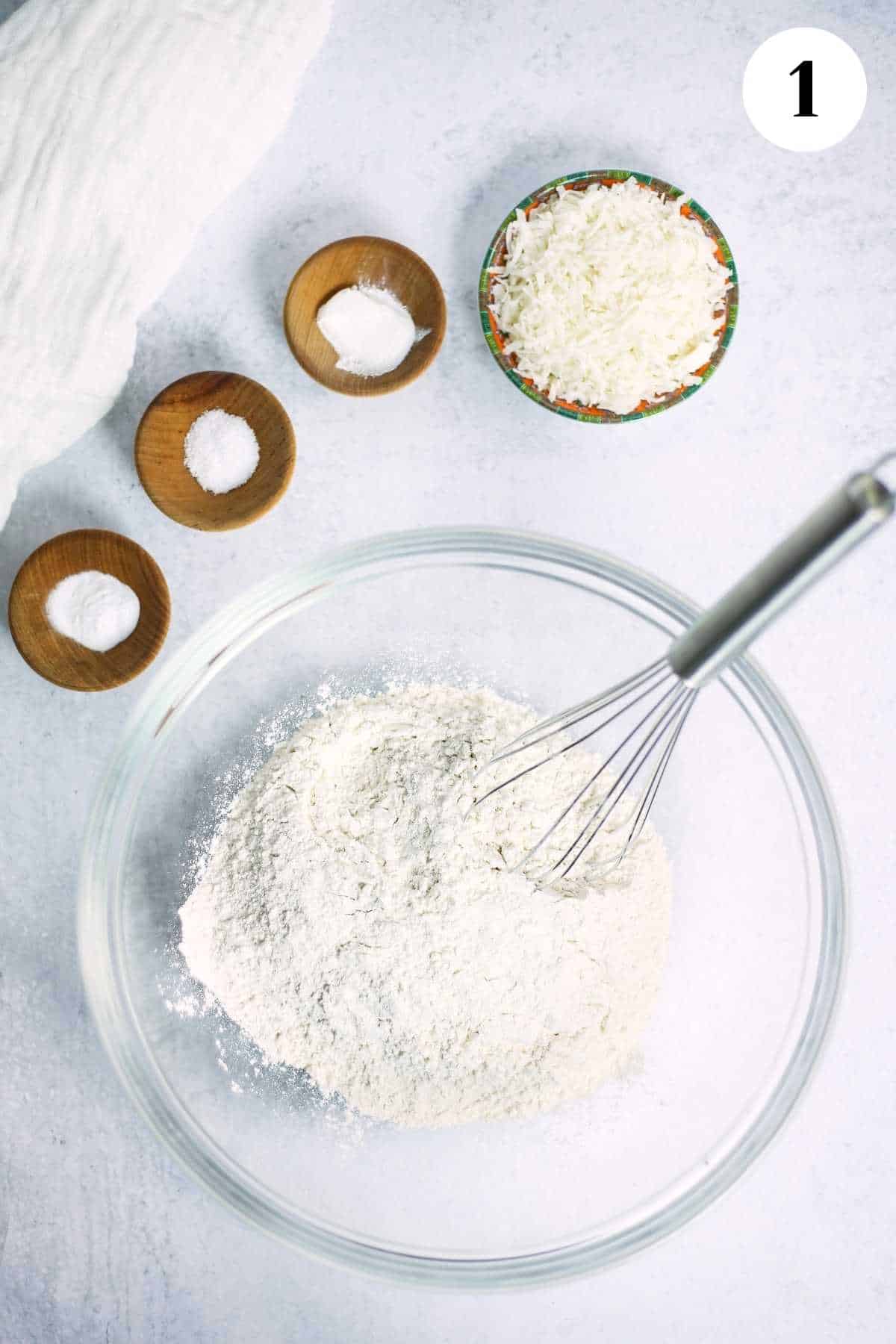 Flour in a mixing bowl with a whisk.