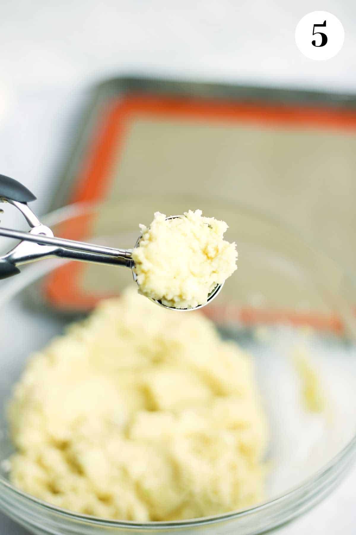 Using a cookie scoop to form the cookies.