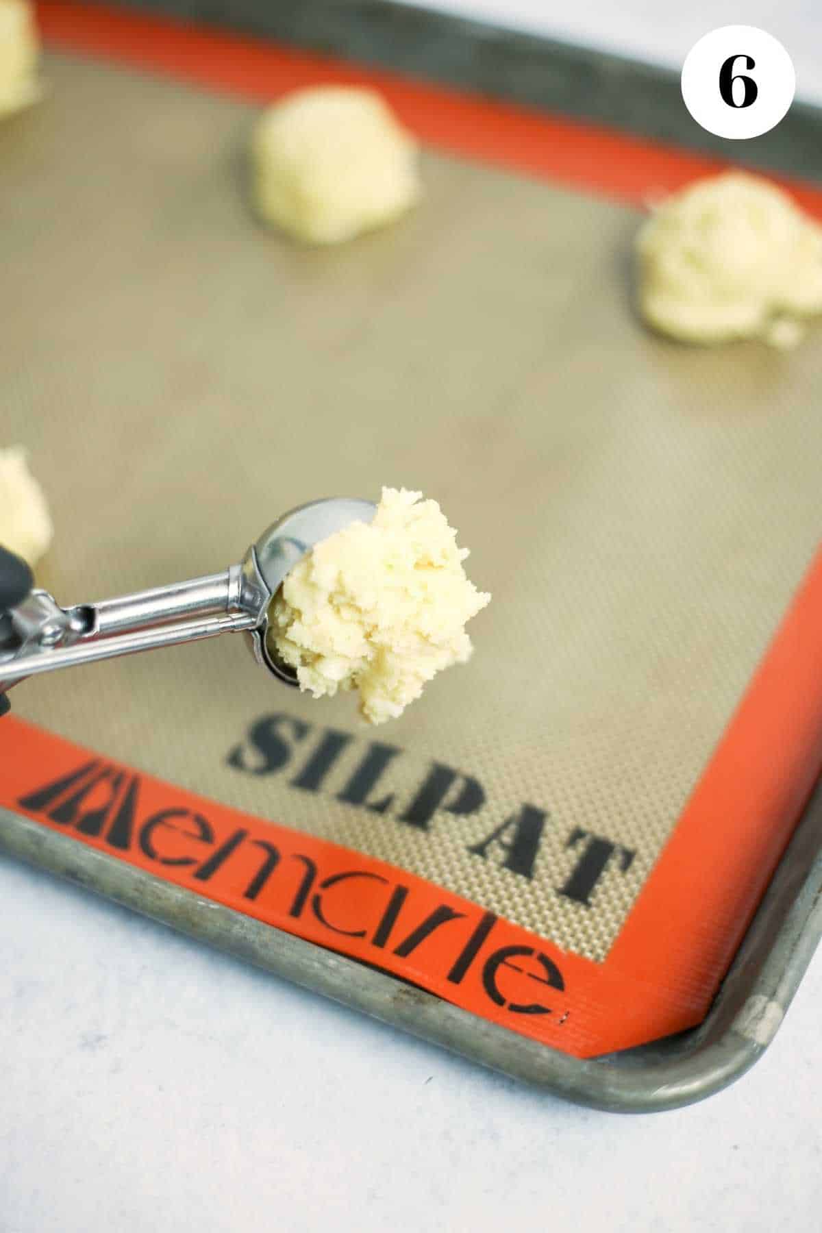 Placing the scooped cookies on a baking tray.