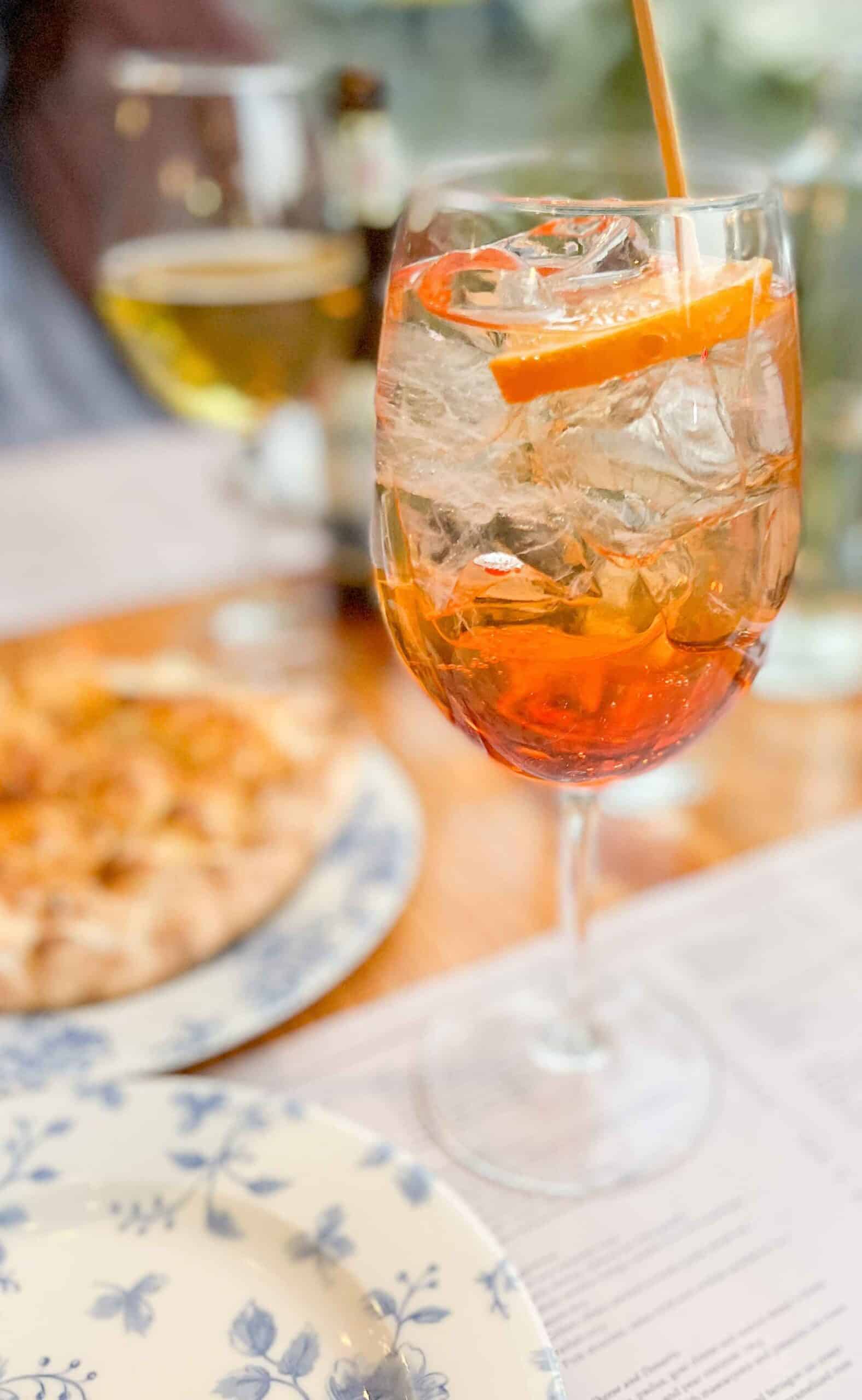 An Aperol Spritz with a white and blue plate at Lardo Restaurant in Mexico City. 