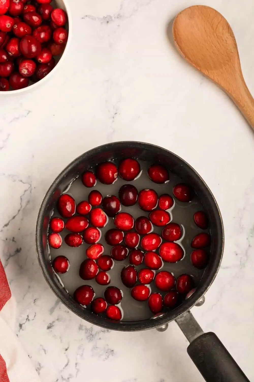 Fresh cranberries cooking in a pot.
