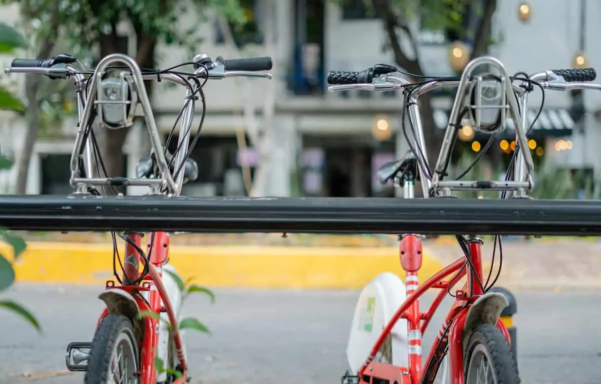 Picture of bicycles parked on a street from Mexico City, and with a blurry building as background.