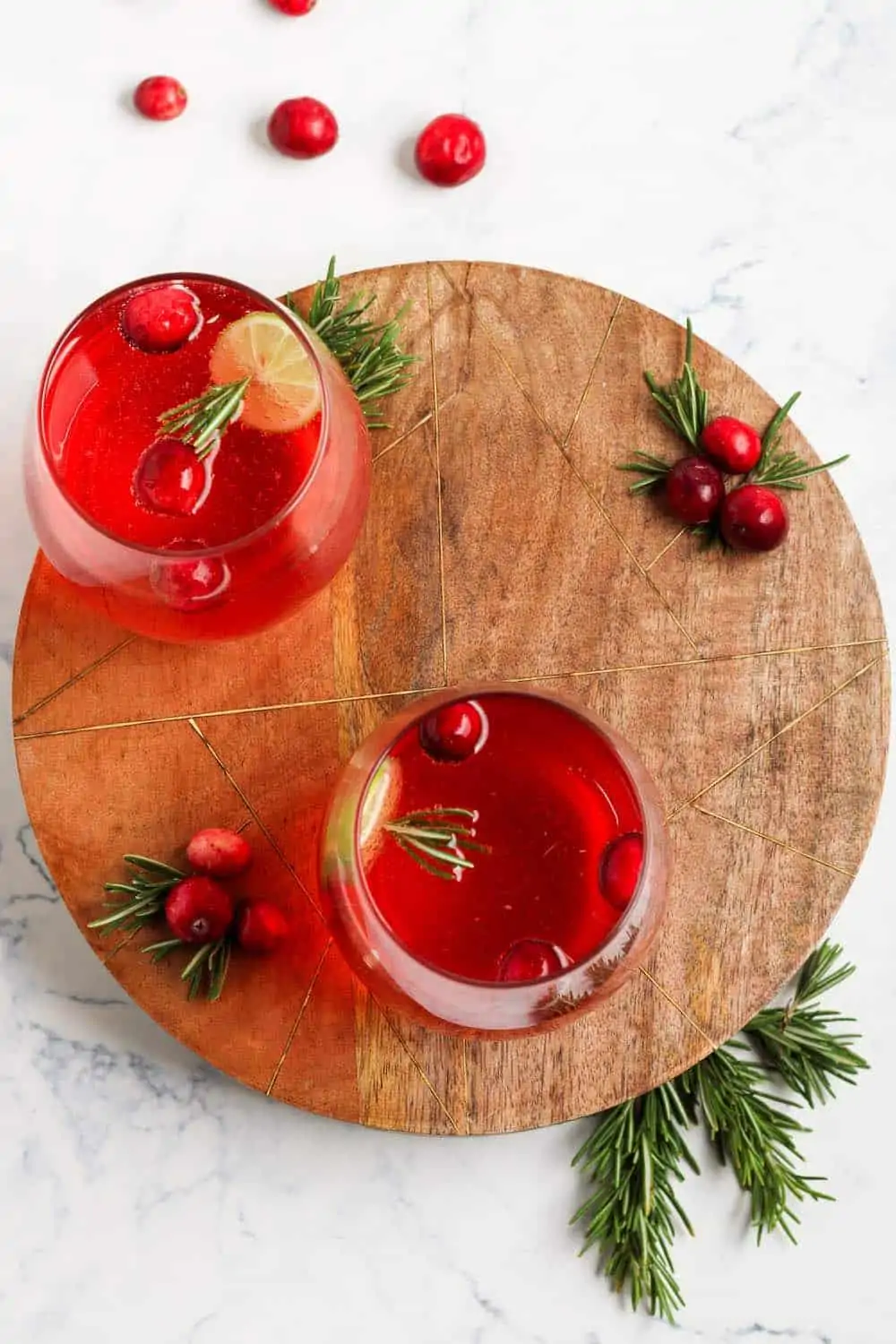 Overhead cranberry juice and processo cocktail on a wooden board.