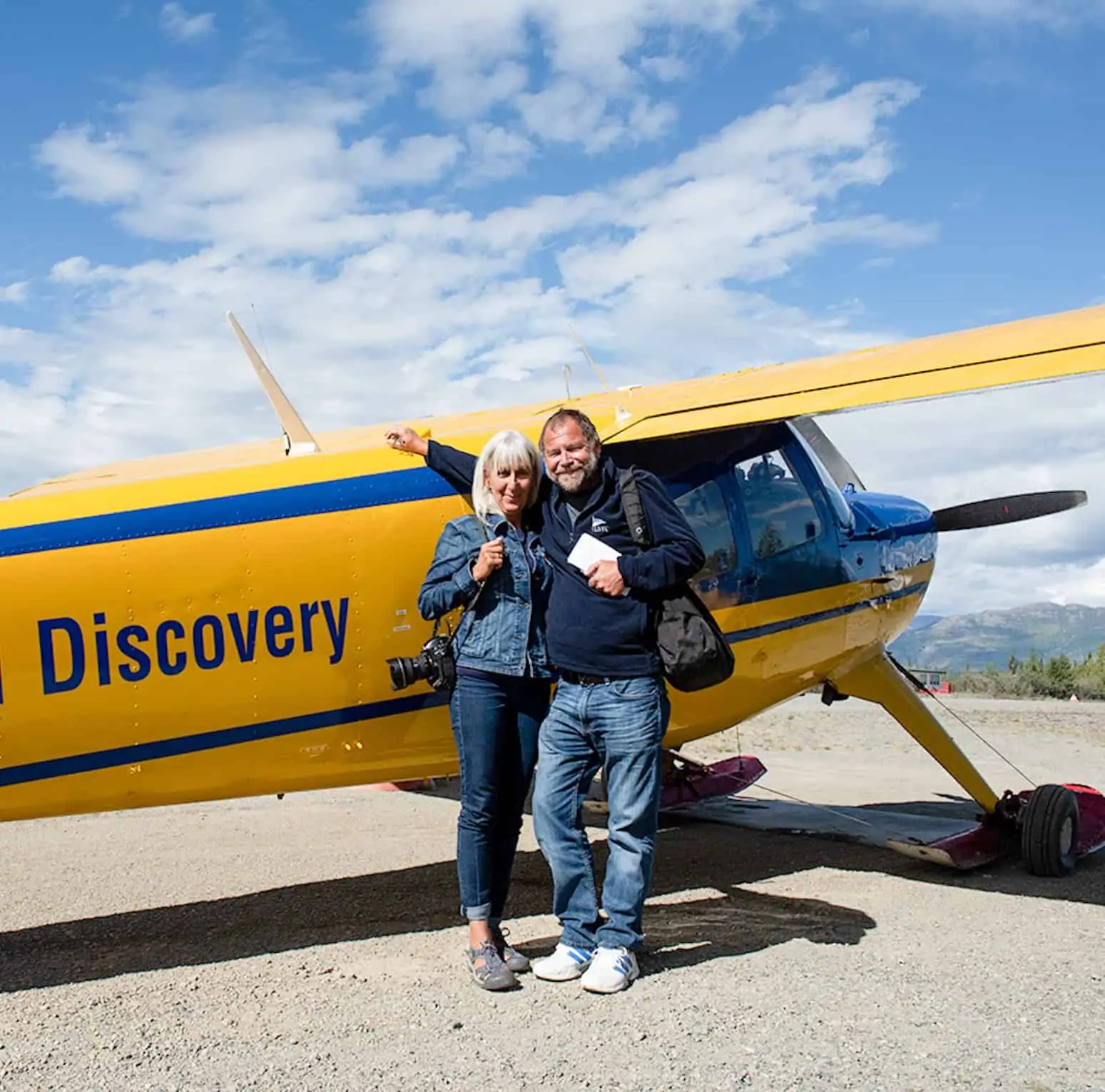 Mark Stevens and Sharon Matthews-Stevens in front of a yellow airplane.