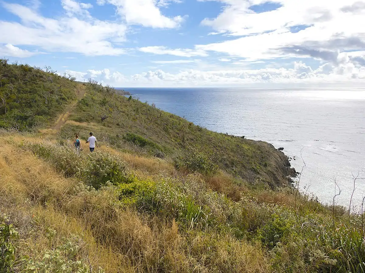 Two people hiking near the water on BVI.