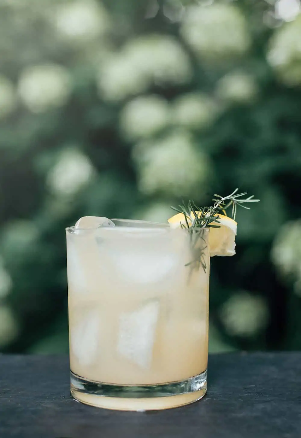 Chamomile cocktail outdoors with green background. n 