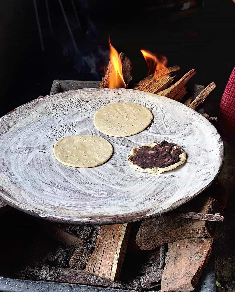 Preparing memelas in Oaxaca over a fire.