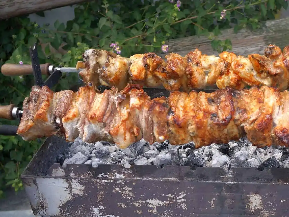 Skewers of soulva cooking on a foukou a traditional grill of Cyprus. 