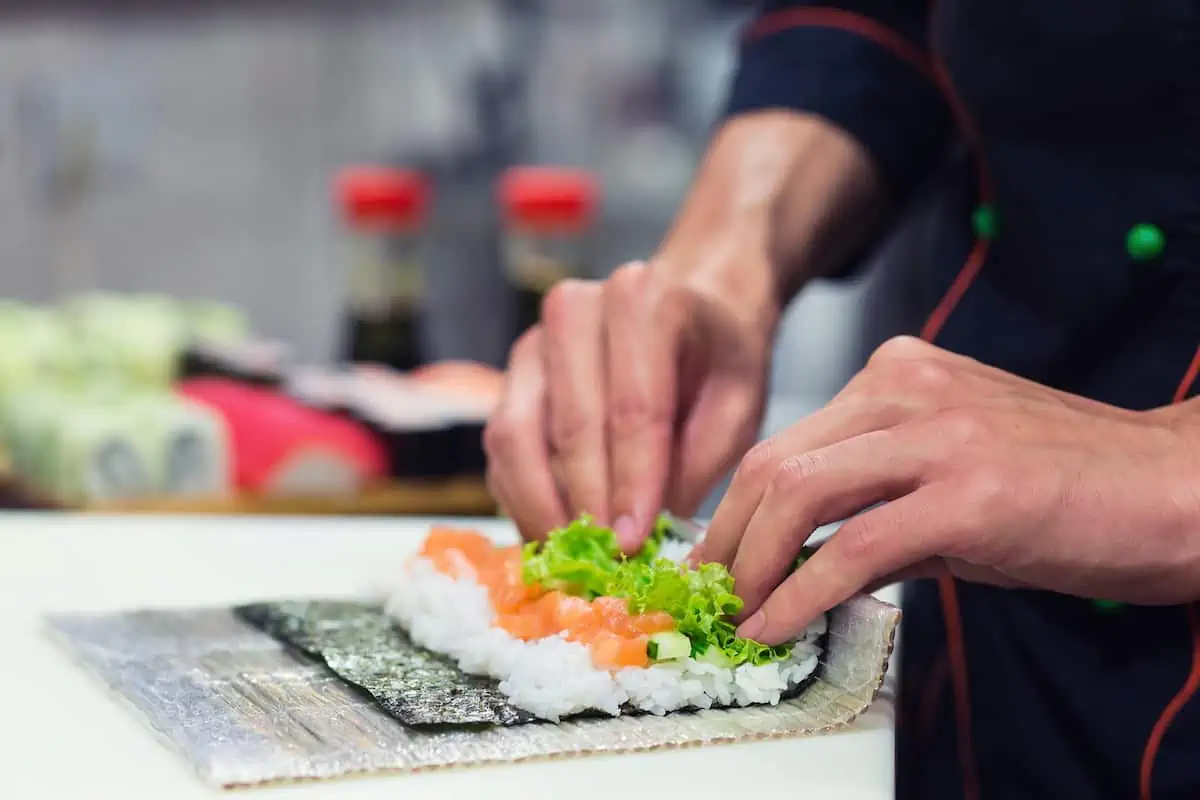 Person making sushi by hand.