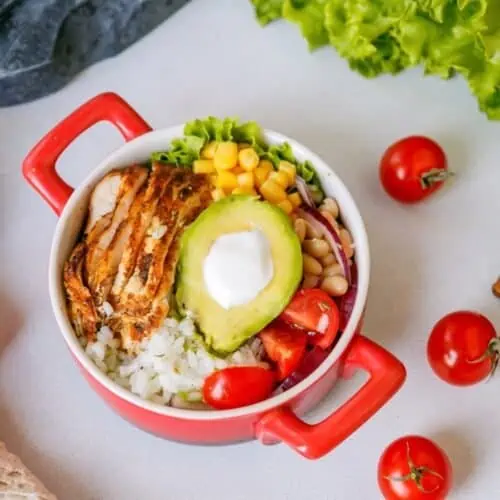 Chipotle chicken and rice bowl in a red dish.