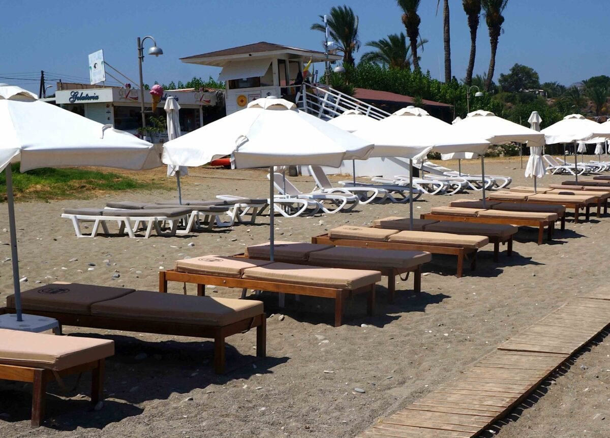 White umbrellas on sandy Polis Beach in Cyprus.