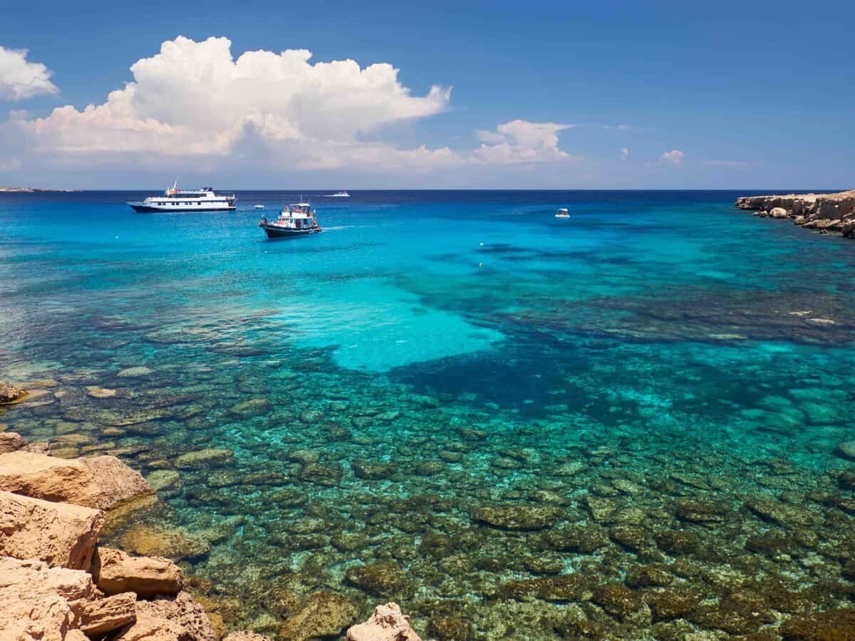 The view of the boats on the crystal clear emerald water of Blue lagoon near Cape Greko (Cape Greco) coast of Cyprus