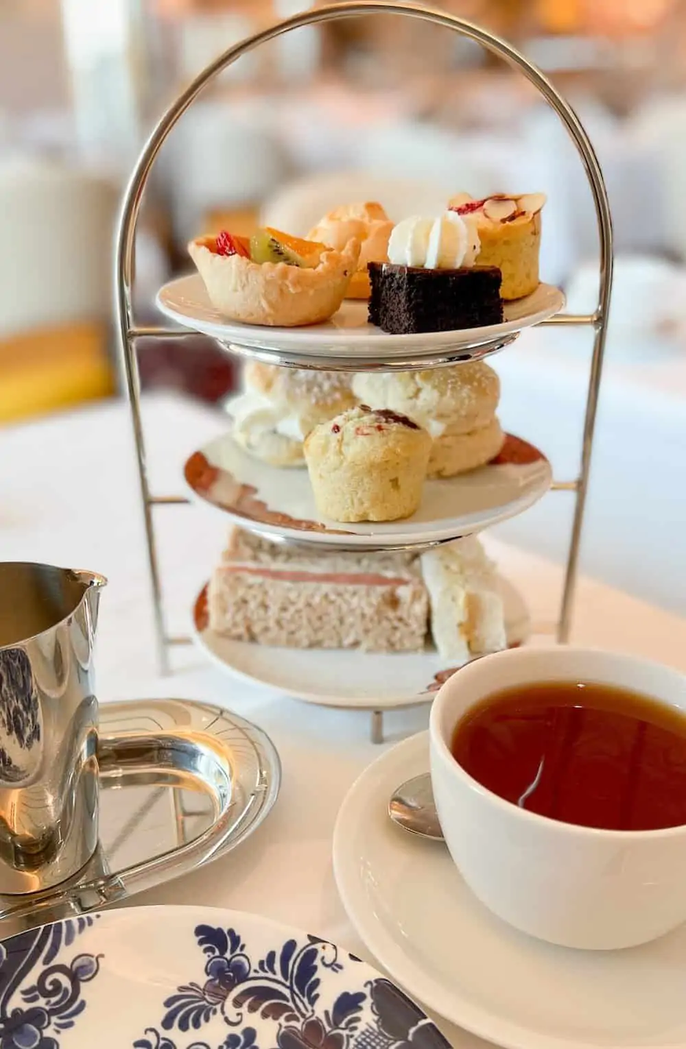 Afternoon tea in a tea stand with a cup of tea. 