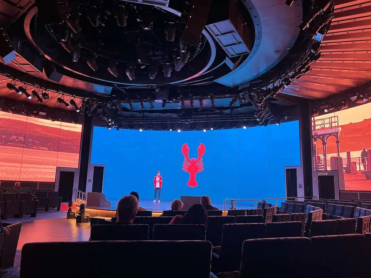 Woman standing on a stage with an image of a lobster.