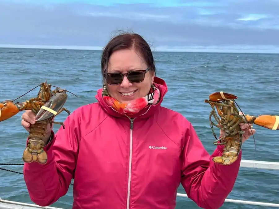 Michele Peterson with two banded lobsters in Nova Scotia.