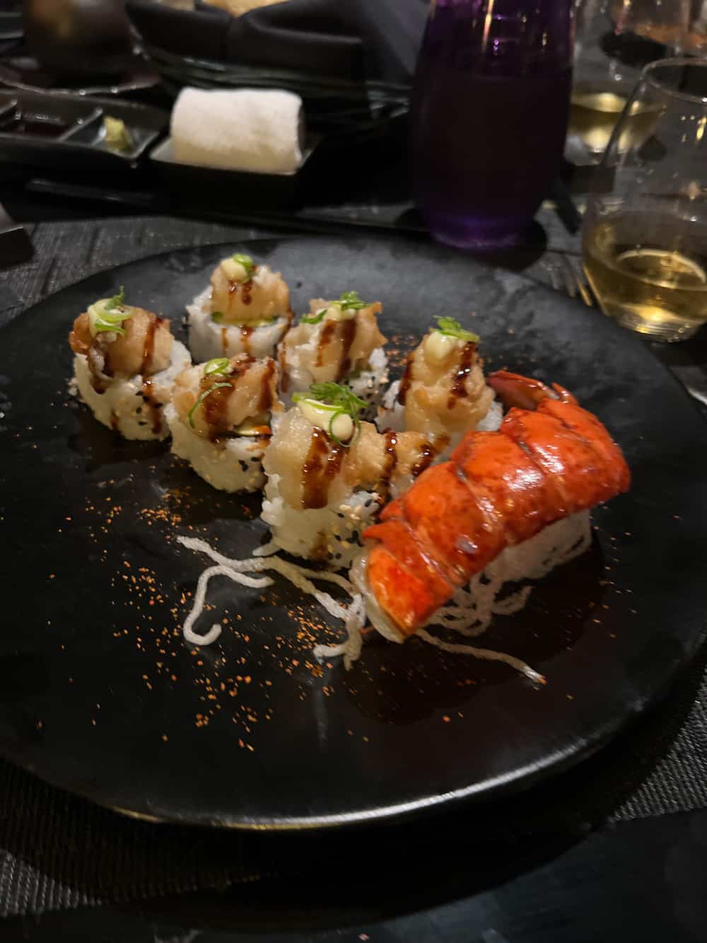 Crispy lobster tempura on a black plate. 