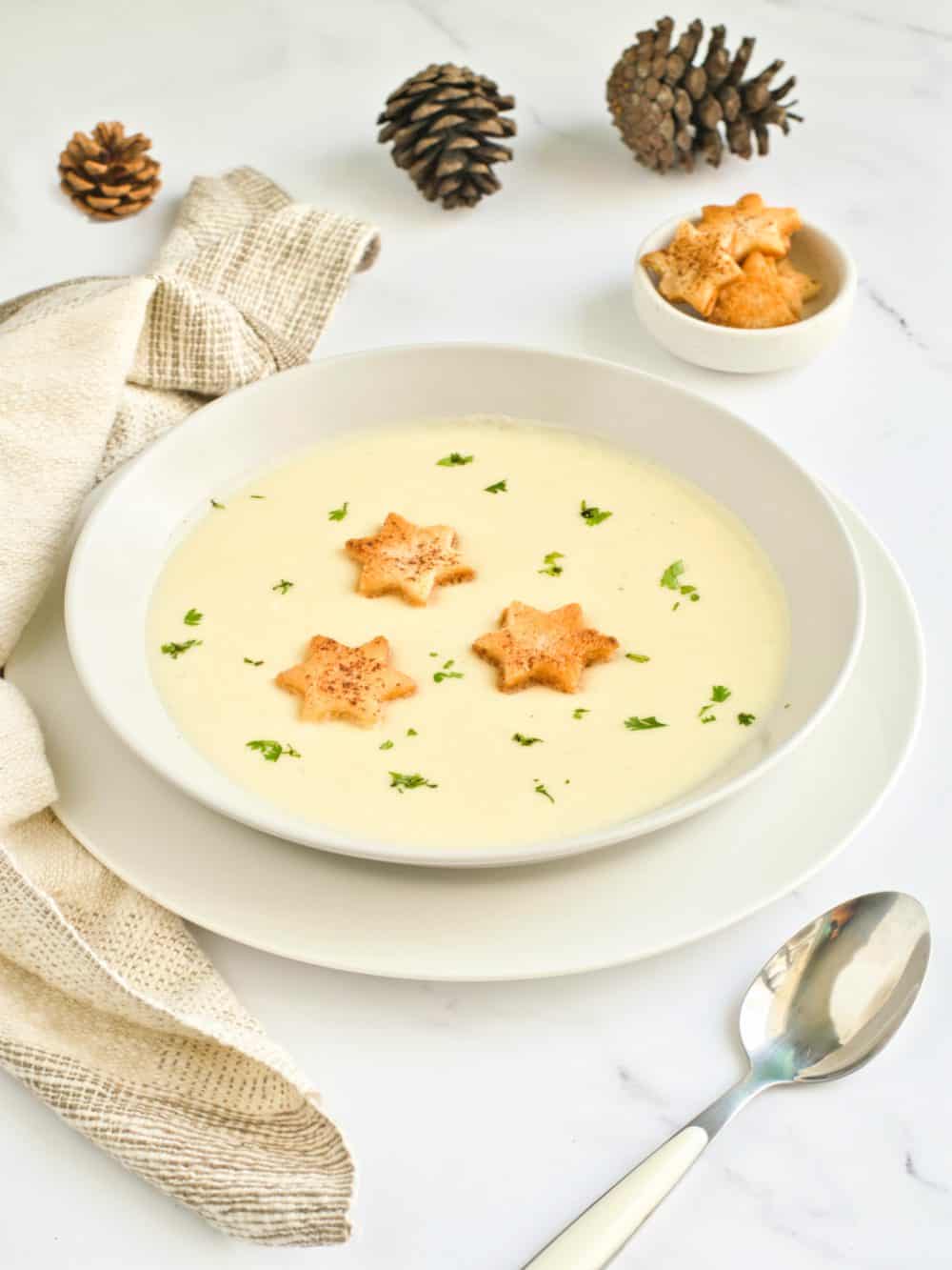 A bowl of Christmas Potato soup with pine cones and star croutons. 