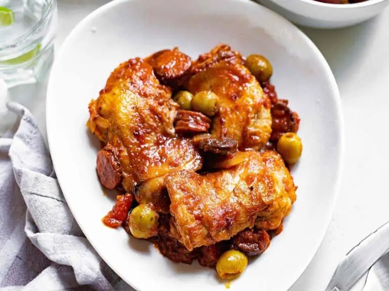 Completed pollo guisado or Spanish chicken and chorizo stew in a white bowl.