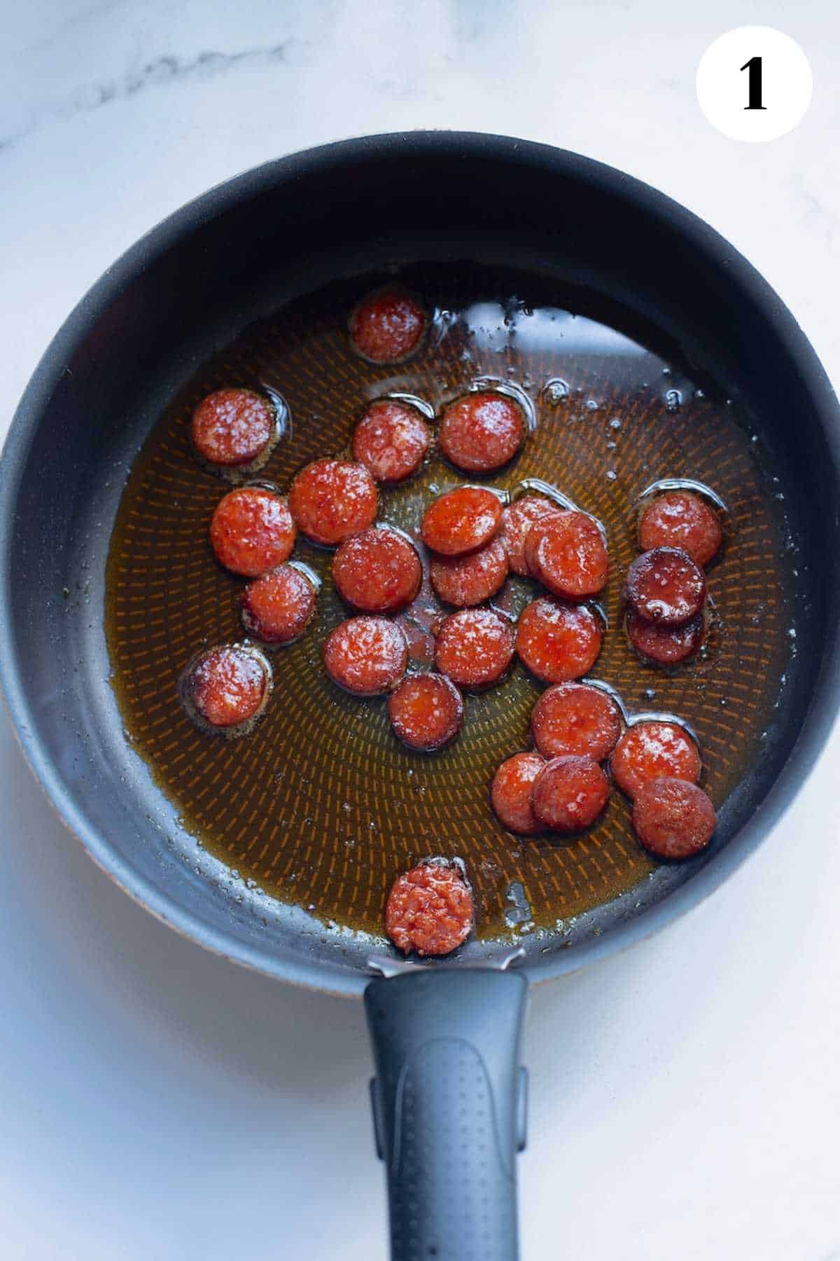 Chorizo browning in a cast iron pan.