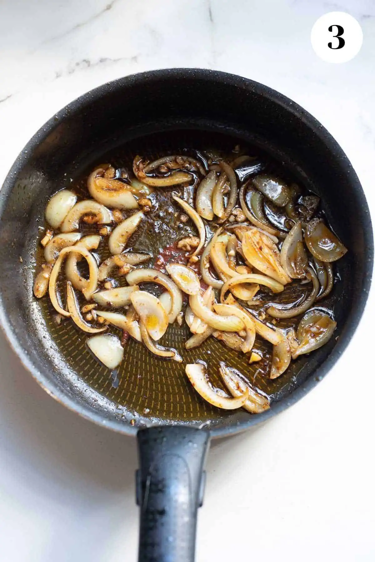 Onions browning in a cast iron pan.