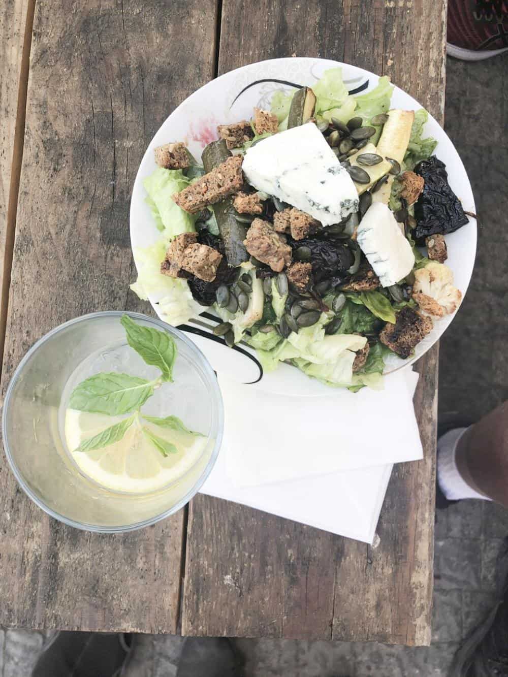 Salad and fresh lemonade at Gina's Cafe on table.