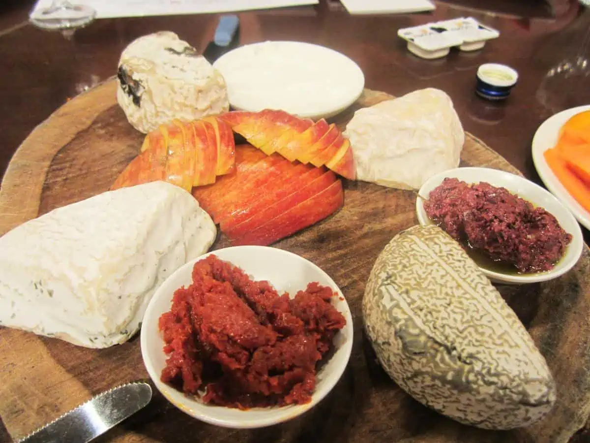 A variety of goat cheeses on wooden platter.