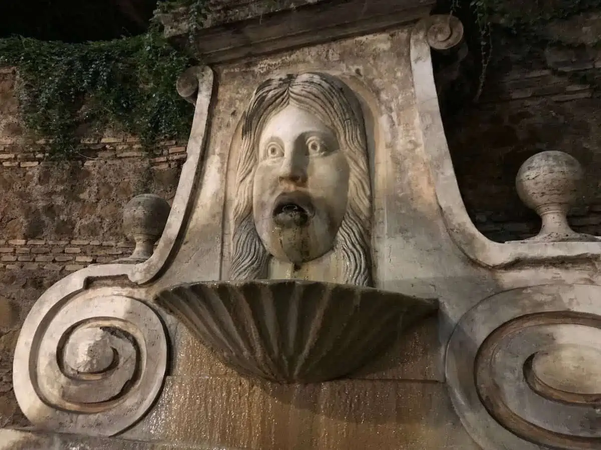 An illuminated fountain in Rome at night. 