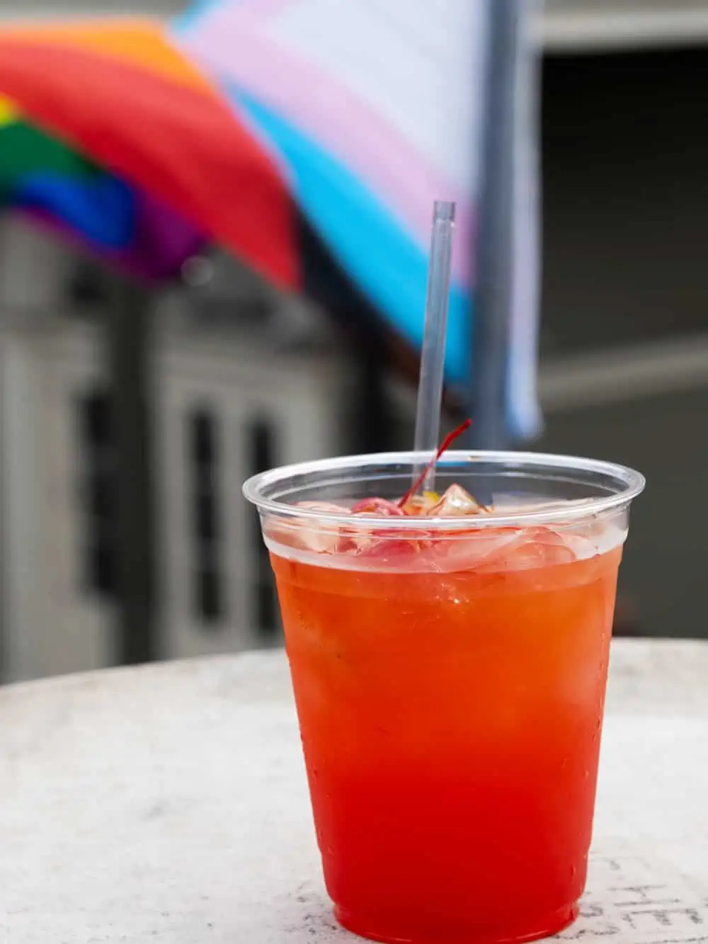 Hurricane cocktail in plastic cup on table.