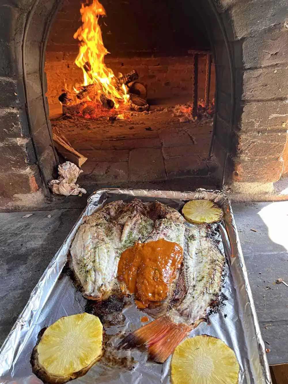Red snapper on a sheet pan being cooked in the horno (adobe oven) at a Puerto Escondido restaurant.