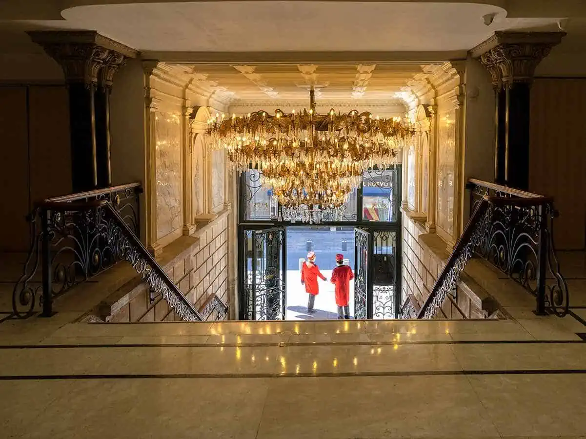 Lobby of the Gran Hotel de Ciudad Mexico with two doormen in red jackets. 