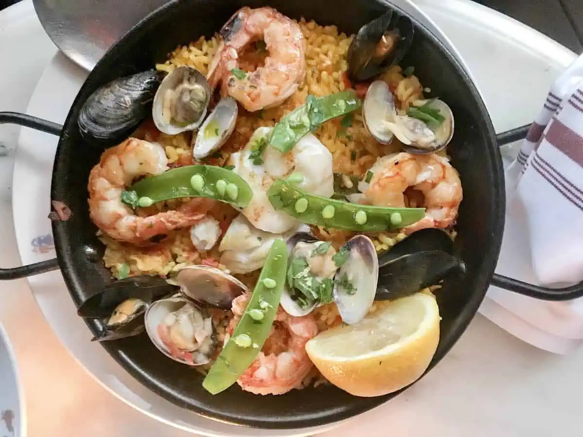 Paella de marisco in a pan with a lemon as garnish. 