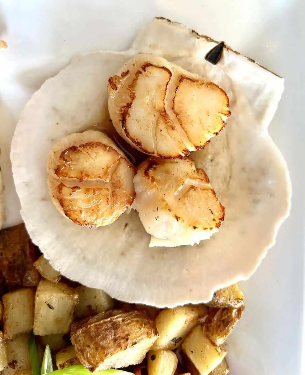 A Digby breakfast featuring scallops sauteed in butter on a half shell. 
