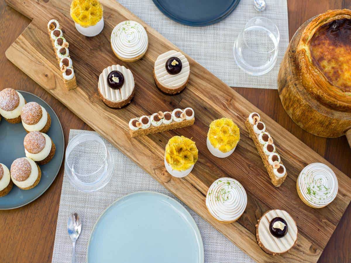 A variety of small desserts on wood on table.