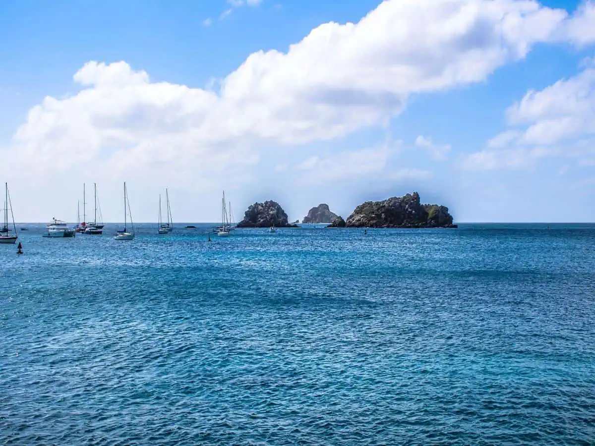 Catamarans in ocean with rocks.