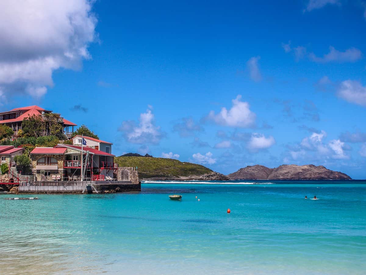 Ocean view with buildings and mountains in the distance.