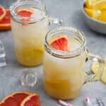 Paloma mezcal cocktails on the table in mason jar glasses with fresh grapefruit.