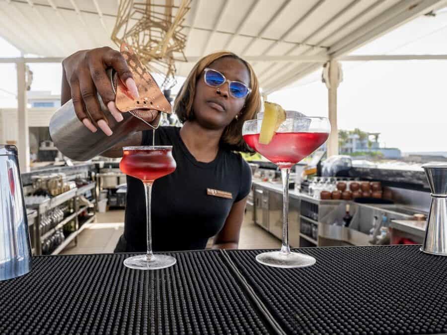 Young woman serving cocktails at Savi Beach bar in Anguilla.
