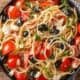 Greek pasta salad in a black bowl.