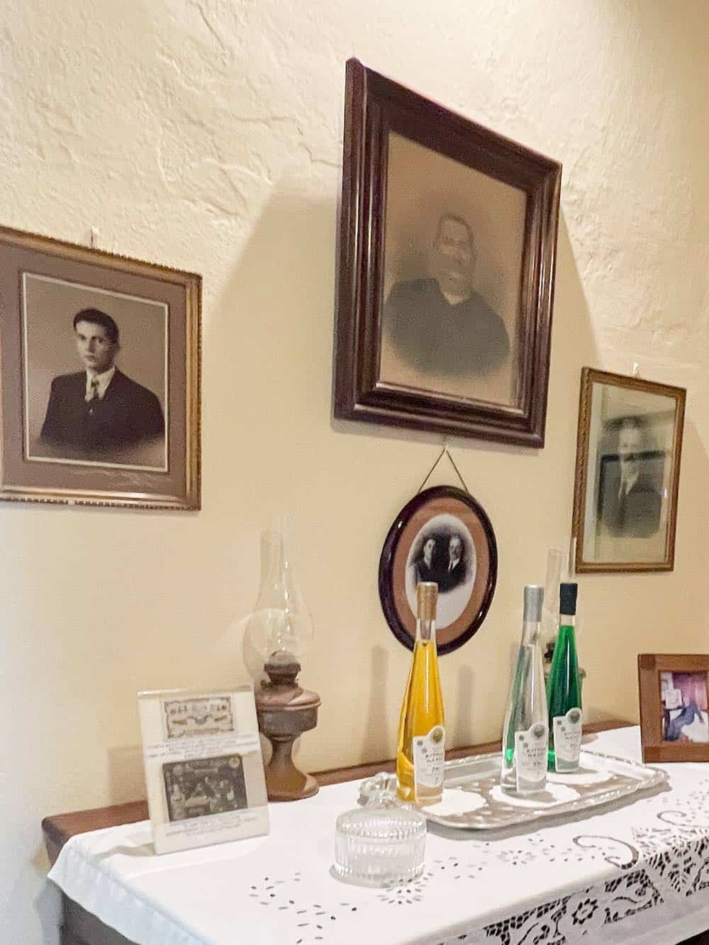 A display of liqueurs and family photos at Vallindras Distillery. 