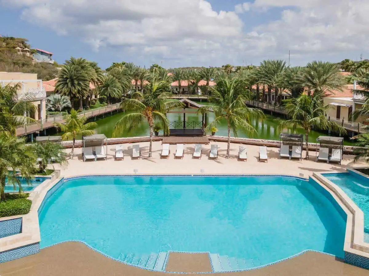 Acoya Curacao Resort's pool with lounge chairs.