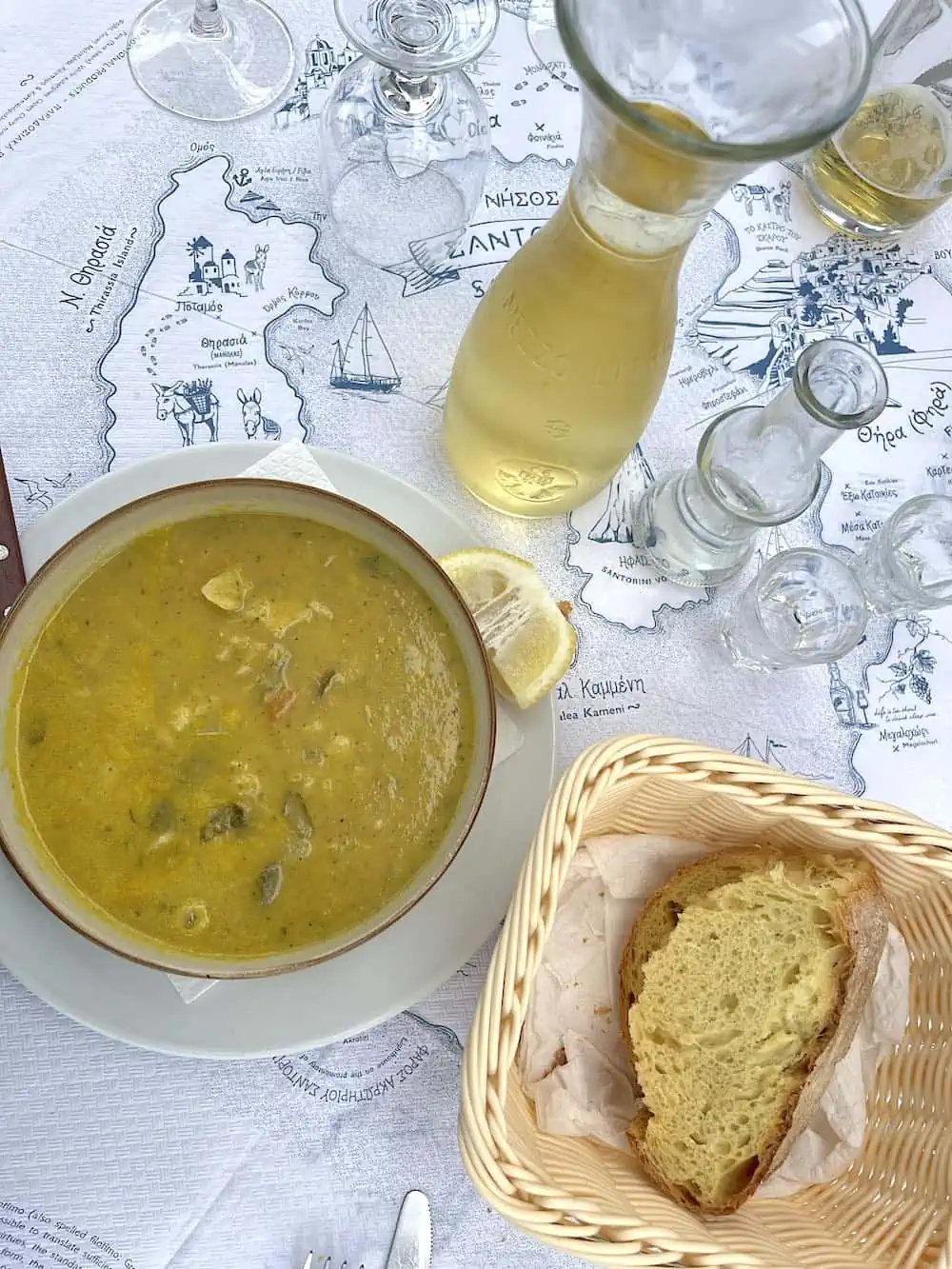 Greek wine and food such as soup and bread in Santorini. 